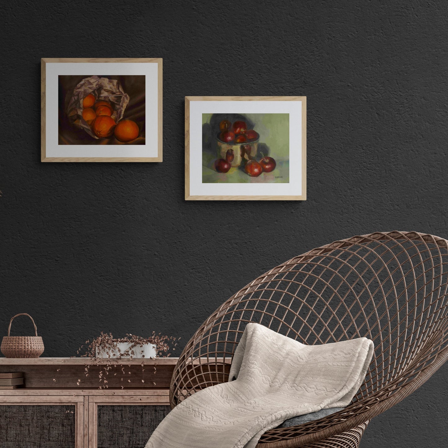 two oil paintings on dark wall with rattan chair and shelving