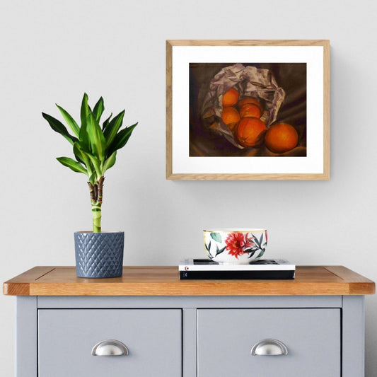 oil painting of oranges spilling out of a paper bag above a cabinet